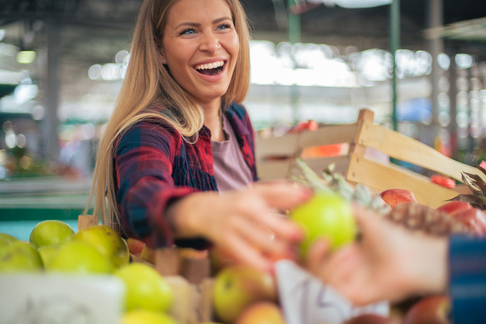 Image of a person smiling and holding an apple